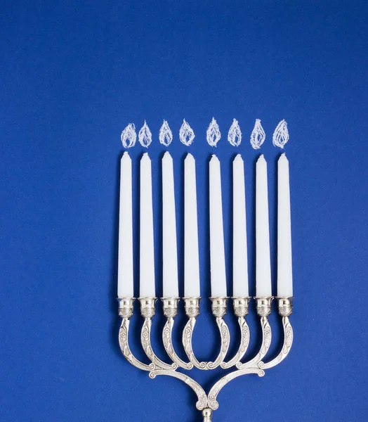 Celebration of Hanukkah. Candlestick on blue background, top view