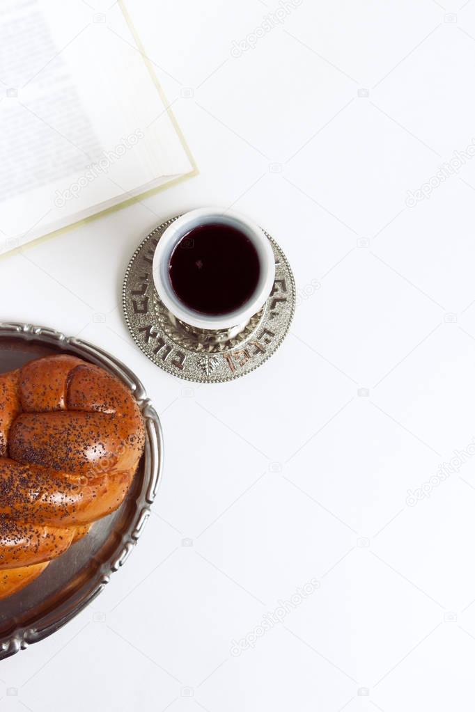 Shabbat shalom, challah with kiddush of wine on a white background. Not isolated, copy space, author processing.
