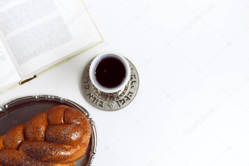 Shabbat Shalom, challah with glass of wine on a white background. Not isolated, copy space, author processing.