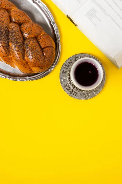 Shabbat shalom, Challah mit Glas Wein und Buch, auf gelbem Hintergrund. nicht isoliert, Kopierraum, Autorenverarbeitung. — Stockfoto