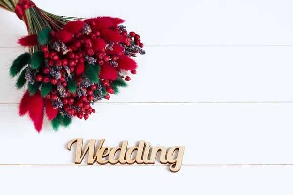 Kytice suchých květin se slovo "svatba" na bílém pozadí dřevěná. Autoři zpracování, selektivní fokus, filmový efekt — Stock fotografie