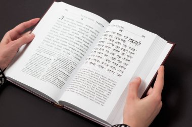 Yahudi kitap, kadının el ile siyah arka plan üzerine. İbranice dua metni. Kadın kitap okumak.