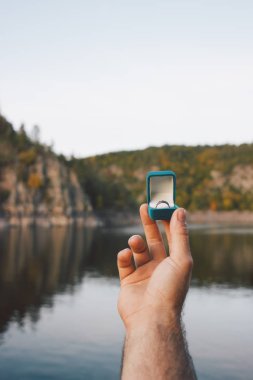 Elinde nişan yüzüğüyle güzel manzaralı mavi bir kulübe tutan adam. Çek Cumhuriyeti 'ndeki Zvikov Kalesi' nde evlenme teklifi. Film efekti, fotoğraf yazma işlemi