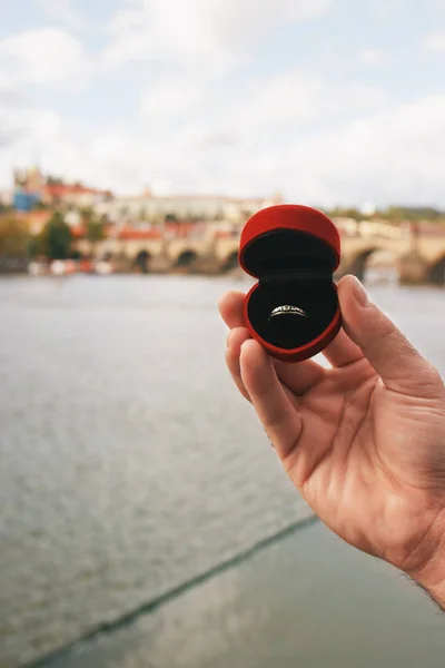 Charles Köprüsü önünde nişan yüzüğü olan kırmızı bir kutu tutan adam. Çek Cumhuriyeti Prag 'da bir evlilik teklifi. Film efekti, fotoğraf yazma işlemi