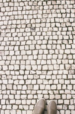 Prag 'daki kaldırımların arka planında spor ayakkabılı bacaklar