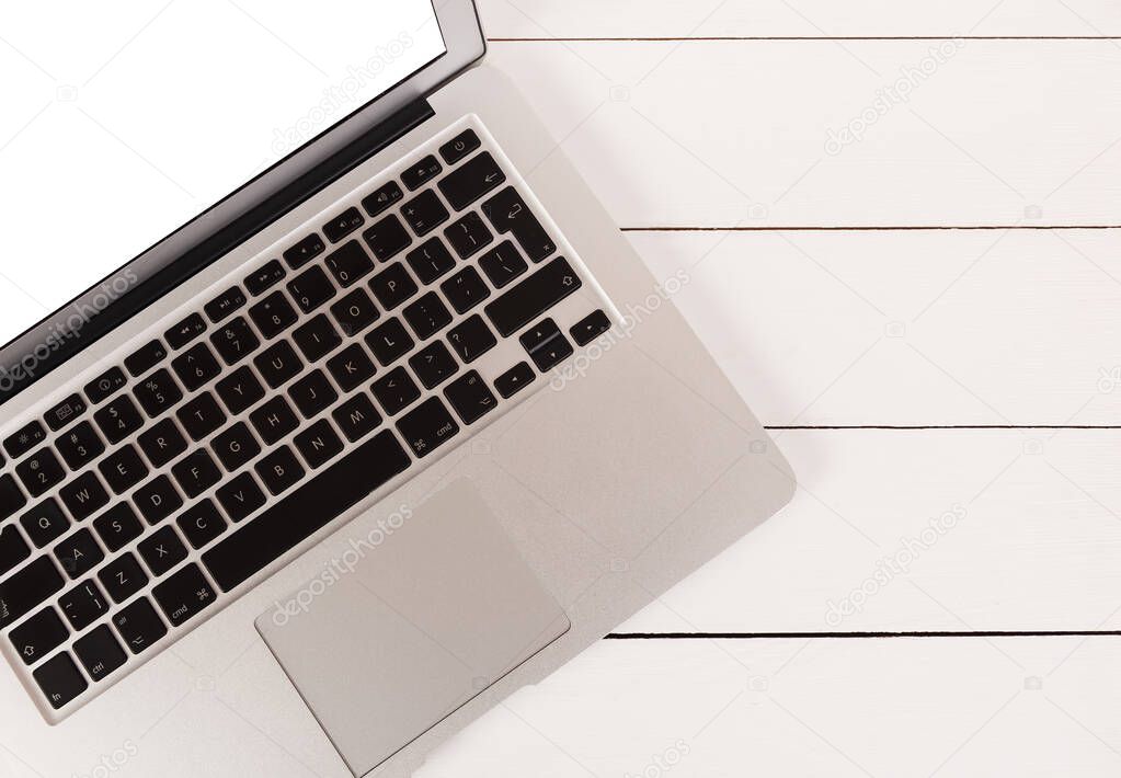 Laptop with white screen on white wooden background with copy-space