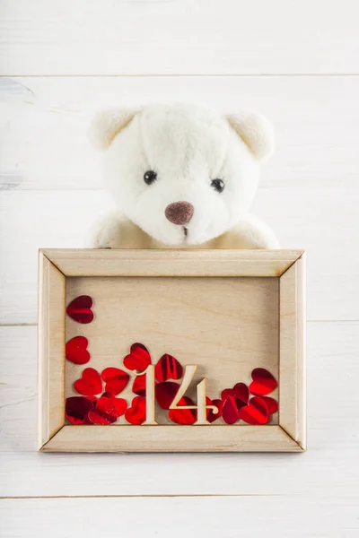 White teddy bear holding plate with hearts. Concept on 14 February. — Stock Photo, Image