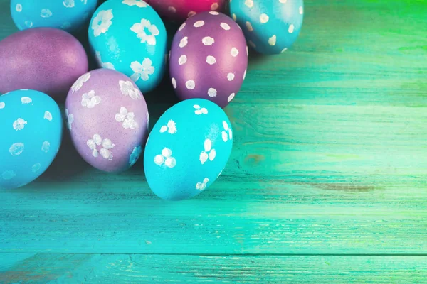 Violet and blue easter eggs on a blue wooden background. Happy easter.