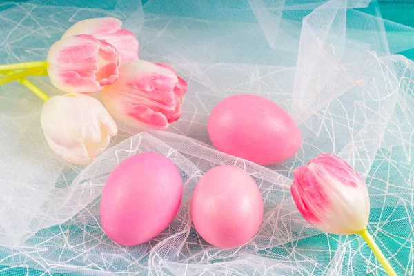 Huevos y tulipanes rosados de Pascua sobre tela blanca y fondo de madera azul . — Foto de Stock