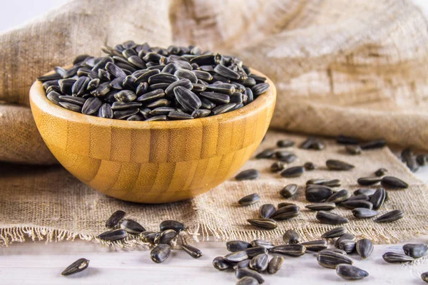 Taze ayçiçeği tohumu. Ahşap kase Ayçekirdeği kabuklu.