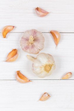 Üstten Görünüm, düz yatıyordu. Diş sarımsak ve sarımsak ampul Beyaz ahşap bir masa üzerinde.