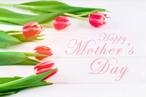 Bouquet of pink tulips on white wooden background. Top view, copy space. Happy mother's day. — Stock Photo, Image