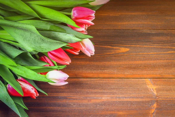 Bouquet de tulipes roses sur fond bois marron. Vue du dessus, espace de copie. Bonne fête des mères . — Photo