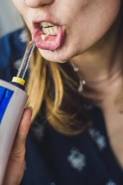 Banyoda oral irrigator kullanan bir kadın