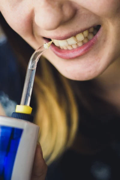 Banyoda oral irrigator kullanan bir kadın