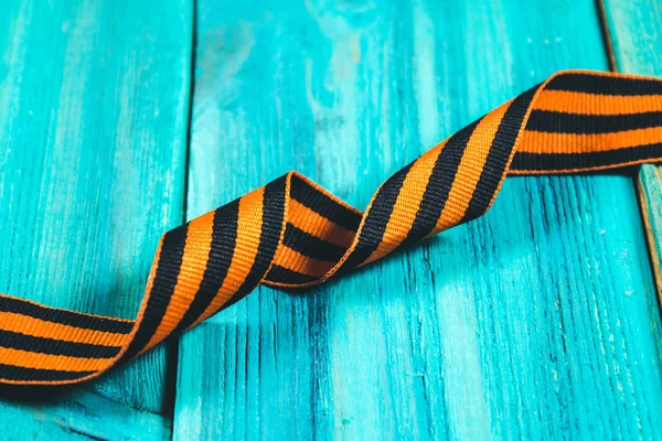 George Ribbon in hands. Symbol of May 9 - George Ribbon striped, orange and black . Memory Soviet victory over Germany in the Great Patriotic War in 1945.