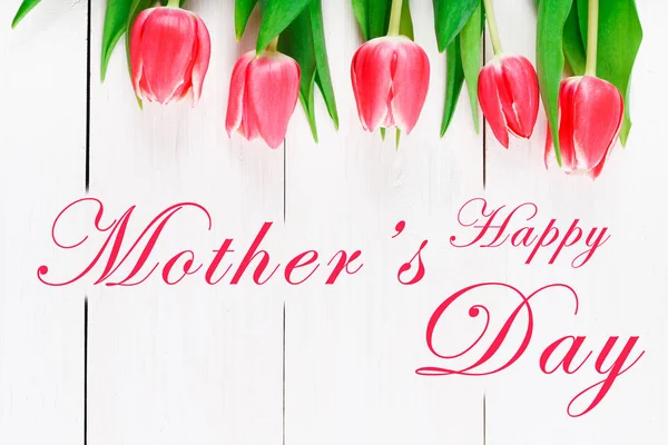 Happy mother's day text sign on pink tulips on white rustic wooden background. greeting card concept. sensual tender women image. spring flowers flat lay — Stock Photo, Image