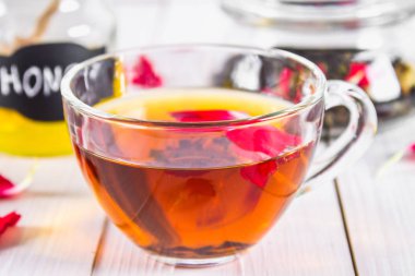 Çiçek siyah çay, bal olabilir, bir beyaz tahta masada yaprakları.