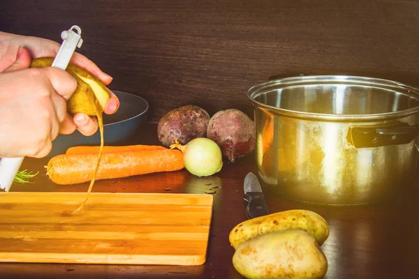 Preparação de sopa ucraniana - borsch. Limpeza e corte de batatas cenouras . — Fotografia de Stock