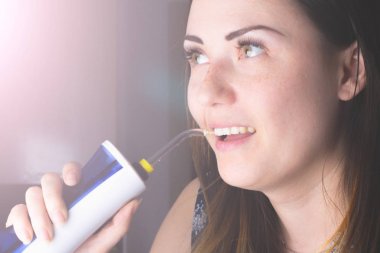 Banyoda oral irrigator kullanan bir kadın