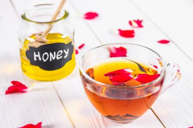 Çiçek siyah çay, bal olabilir, bir beyaz tahta masada yaprakları.