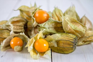Egzotik meyveler physalis Beyaz ahşap bir masa üzerinde.