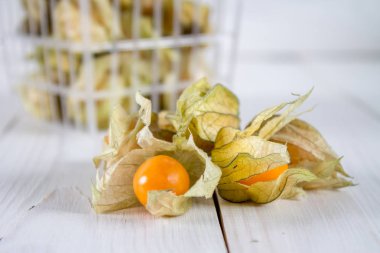 Egzotik meyveler physalis Beyaz ahşap bir masa üzerinde.