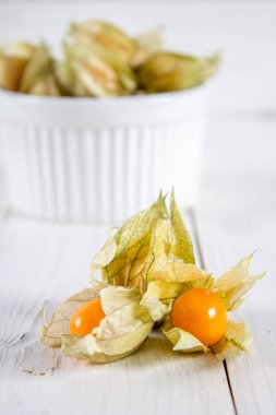 Egzotik meyveler physalis Beyaz ahşap bir masa üzerinde.