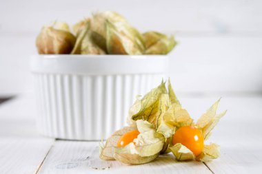 Egzotik meyveler physalis Beyaz ahşap bir masa üzerinde.