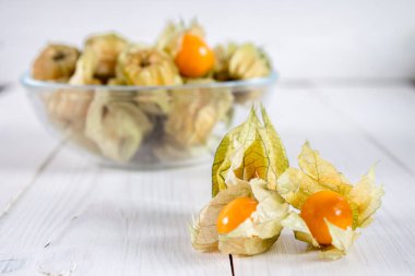 Egzotik meyveler physalis Beyaz ahşap bir masa üzerinde.