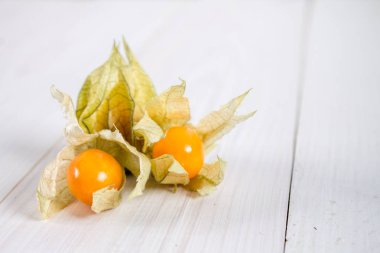 Egzotik meyveler physalis Beyaz ahşap bir masa üzerinde.