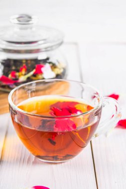 Bir bardak çay, bir banka bir siyah bitkisel fl ile arka planda