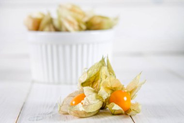 Egzotik meyveler physalis Beyaz ahşap bir masa üzerinde.