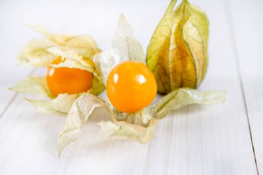 Egzotik meyveler physalis Beyaz ahşap bir masa üzerinde.