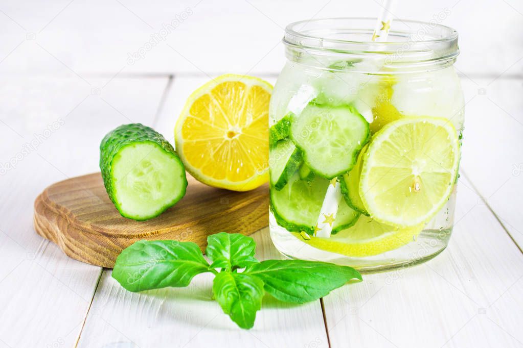 Sassy diet water. Cucumber, lemon, mint lemonade in glasses on white wooden table.