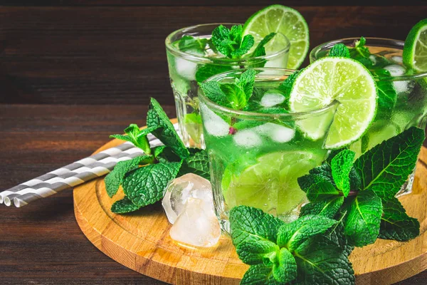 Mojito com hortelã e limão em um copo e um jarro no javali redondo — Fotografia de Stock