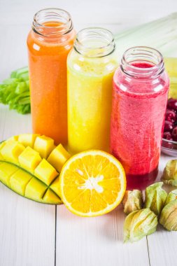 Mango, portakal, muz, cele şişelerde çok renkli smoothies
