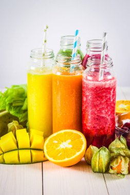 Mango, portakal, muz, cele şişelerde çok renkli smoothies