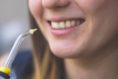 Banyoda oral irrigator kullanan bir kadın