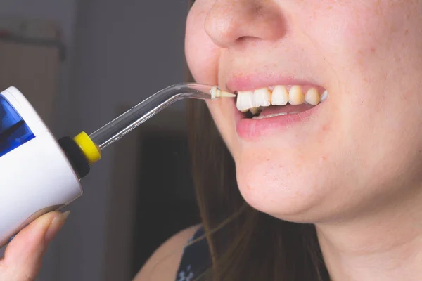 Banyoda oral irrigator kullanan bir kadın