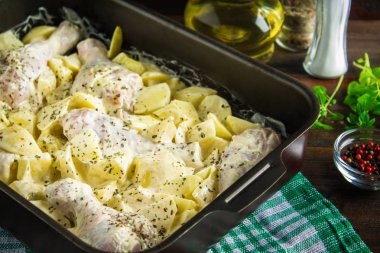 Çiğ tavuk budu mayonez üzerinde ahşap bir masa pişirme için formunda ham patates ile. Et yemek pişirmek için malzemeler. Tarifi.