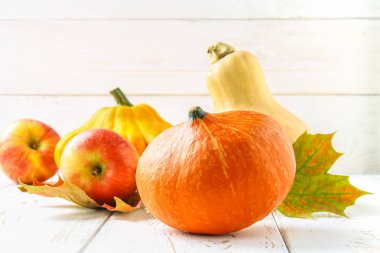 Kabak ve patty pan, elma ve akçaağaç, meşe sarı bir beyaz tahta masada bırakır. Sonbaharda hasat.