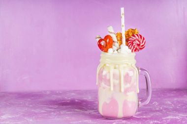 Pembe yüzlü, krem üzerinden Freakshake. Lolipop, waffle ve hatmi ile Monstershake. Bir Mason kavanoza aşırı milkshake. Mor pembe.