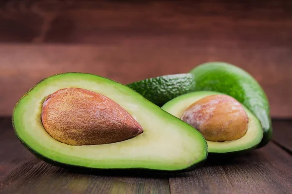 Lebensmittel Hintergrund mit frischer Bio-Avocado auf altem Holztisch, — Stockfoto