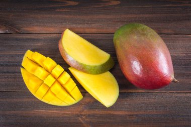 Tropikal meyve mango ahşap arka plan, Bütün veya dilimlenmiş üzerinde.