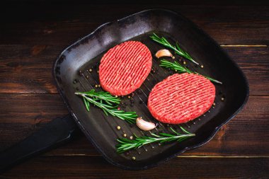 Ham pirzola biberiye ve sarımsak ile pan. Ahşap kahverengi adam