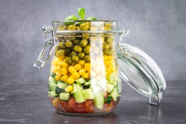 Sağlıklı ev yapımı salata sebze, salatalık, domates, bezelye ve Mısır - sağlıklı diyet, Detoks, saf gıda veya vejetaryen kavramı ile bir kavanoz içinde