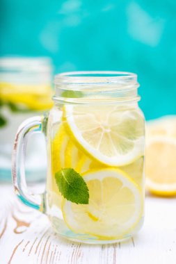 Beyaz ahşap zemin üzerine bankalar ile soğuk limonata kulplu. Limon.