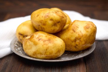 Çiğ patates kahverengi ahşap arka plan üzerinde