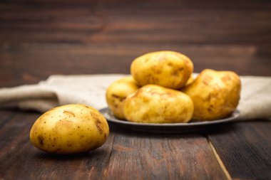 Çiğ patates kahverengi ahşap arka plan üzerinde